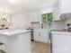 Bright kitchen with island, white cabinets, modern lighting, and stainless steel appliances at 1831 Erie St, Charlotte, NC 28216