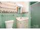 Bathroom with pastel green tiling, classic vanity, and convenient built-in shelves at 215 Jan Mar Dr, China Grove, NC 28023