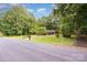 A charming brick home with a well-maintained lawn and mature trees sits behind a wooden fence at 215 Jan Mar Dr, China Grove, NC 28023