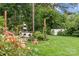 Lush backyard with seating area, mature trees, storage shed and flower beds for outdoor relaxation at 227 Wingrave Dr, Charlotte, NC 28270