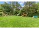 Spacious backyard showcasing a playset, seating area, shed, and ample green space for outdoor enjoyment at 227 Wingrave Dr, Charlotte, NC 28270
