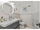 Bathroom featuring a modern vanity, round mirror, wainscotting, and patterned tile flooring at 227 Wingrave Dr, Charlotte, NC 28270