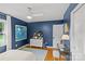 Bedroom features dark blue walls, hardwood floors, a workspace, and a patterned rug at 227 Wingrave Dr, Charlotte, NC 28270