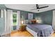Cozy bedroom features a ceiling fan, accent wall, and natural light from a nearby window at 227 Wingrave Dr, Charlotte, NC 28270