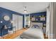 Blue bedroom with hardwood floors, a workspace, and plenty of storage at 227 Wingrave Dr, Charlotte, NC 28270