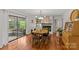 Open dining room with hardwood floors, fireplace, modern chandelier, and access to outdoor living space at 227 Wingrave Dr, Charlotte, NC 28270