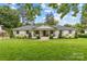 Charming ranch-style home with a manicured lawn, lush landscaping and inviting front porch swings at 227 Wingrave Dr, Charlotte, NC 28270