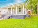 Exterior view of a charming home with a covered porch, black railings, and well-kept landscaping at 2440 Myers St, Gastonia, NC 28056