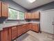 Well-lit kitchen features wood cabinets, granite countertops, stainless sink, and vinyl flooring at 2440 Myers St, Gastonia, NC 28056