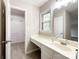 Bright bathroom with a white vanity, window, and an adjacent room with a walk-in closet at 2619 Quailrush Rd, Charlotte, NC 28226