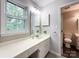 Bathroom with a white vanity, window, and a door leading to an adjacent toilet and shower area at 2619 Quailrush Rd, Charlotte, NC 28226