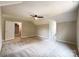 Large bedroom with a ceiling fan, plush carpet, neutral paint, and an entry to an adjacent room at 2619 Quailrush Rd, Charlotte, NC 28226