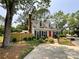 View of the home from the driveway, including a fenced yard, mature trees, and a landscaped front yard at 2619 Quailrush Rd, Charlotte, NC 28226