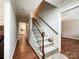 Inviting hallway with a carpeted staircase, wooden handrail, and neutral wall colors at 2619 Quailrush Rd, Charlotte, NC 28226
