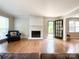Bright living room showcasing hardwood floors, a white-painted fireplace, and access to the front entrance at 2619 Quailrush Rd, Charlotte, NC 28226