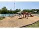 Community playground featuring modern play equipment and a safety surface, adjacent to the pool at 2619 Quailrush Rd, Charlotte, NC 28226