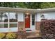 Home's front entrance with a red door, brick accents, and bright windows, surrounded by manicured landscaping at 2666 Providence Dr, Gastonia, NC 28052