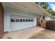 Attached garage with a large door and a red door, surrounded by brick accents and manicured landscaping at 2666 Providence Dr, Gastonia, NC 28052
