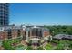 Expansive aerial view of a vibrant community featuring lush landscaping and elegant brick buildings with a city skyline backdrop at 300 W 5Th St # 812, Charlotte, NC 28202