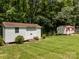 Large backyard with two sheds, a lawn and surrounded by mature trees at 303 Jean Ave, Kannapolis, NC 28083