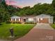 Charming brick home with manicured lawn, covered carport, and a classic American style at 303 Jean Ave, Kannapolis, NC 28083