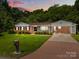 Charming brick home with manicured lawn, covered carport, and a classic American style at 303 Jean Ave, Kannapolis, NC 28083