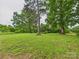 Lush backyard featuring a large grassy area and mature trees, creating a serene outdoor space at 3055 16Th Ne St, Hickory, NC 28601