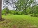 Spacious backyard with mature shade trees and lush green grass at 3055 16Th Ne St, Hickory, NC 28601