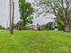 Expansive front lawn with mature trees leading to a charming home with a covered porch at 3055 16Th Ne St, Hickory, NC 28601