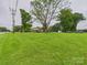 Grassy front yard with mature trees offers a welcoming view with road access to the neighborhood at 3055 16Th Ne St, Hickory, NC 28601