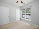 Bright bedroom with neutral carpet, large window with blinds, and white doors creates a serene living space at 3248 Margellina Dr, Charlotte, NC 28210