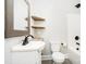 Cozy bathroom with a pedestal sink, framed mirror, and open wood shelving at 330 Central Ave, Kannapolis, NC 28081