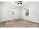 Light-filled bedroom with neutral carpeting, ceiling fan, and bright windows at 330 Central Ave, Kannapolis, NC 28081
