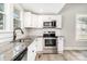 Updated kitchen boasts granite counters, white cabinetry, stainless appliances, and modern fixtures at 330 Central Ave, Kannapolis, NC 28081