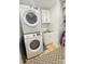A functional laundry room with stacked washer and dryer, cabinetry, and shelving for organized storage at 3416 Yarmouth Ln, Gastonia, NC 28056