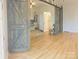 Living room view with barn doors leading to a bedroom and ensuite bathroom, showcasing the open layout at 3416 Yarmouth Ln, Gastonia, NC 28056