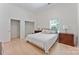 Bright bedroom features two matching wood dressers and a bed with a view of a walk-in closet at 364 Luther Dr, Iron Station, NC 28080