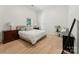 Bright, minimalist bedroom with light wood floors, a cozy bed, and vintage wood dressers at 364 Luther Dr, Iron Station, NC 28080