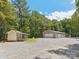 Wide shot of a well-kept house with a three-car garage and an outbuilding in a stone yard at 364 Luther Dr, Iron Station, NC 28080
