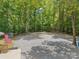 View of a stone yard with the American flag, mature trees, and stairs leading to an entrance at 364 Luther Dr, Iron Station, NC 28080