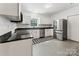 Well-lit kitchen featuring white cabinetry, granite countertops, and stainless steel appliances with a checkered-tile accent at 364 Luther Dr, Iron Station, NC 28080