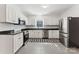 Modern kitchen featuring white cabinets, granite countertops, stainless steel appliances, and a checkered accent floor at 364 Luther Dr, Iron Station, NC 28080