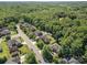 Aerial view of a neighborhood with mature trees, well-manicured lawns, and a private pool at 3917 Erskine Woods Dr, Bessemer City, NC 28016