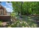 Landscaped backyard showing mature trees and greenery with fencing around the backyard of the home at 3917 Erskine Woods Dr, Bessemer City, NC 28016