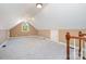 Spacious bonus room with neutral carpet, window, and a view of the neighborhood from the stairway at 3917 Erskine Woods Dr, Bessemer City, NC 28016