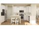 Modern kitchen with white cabinets, stainless steel appliances, breakfast bar, and hardwood floors at 4247 Skyboat Cir, Fort Mill, SC 29715