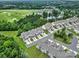 Aerial view of townhomes, a pond with fountains, and a golf course surrounded by lush greenery at 45008 Wigeon Ln # 202, Indian Land, SC 29707