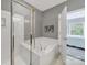 Bathroom with a large bathtub, enclosed shower, gray walls, and white trim at 45008 Wigeon Ln # 202, Indian Land, SC 29707