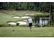 Scenic view of the golf course with lush green fairways, sand traps and pond with golfers visible in the distance at 45008 Wigeon Ln # 202, Indian Land, SC 29707