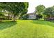 Sprawling green backyard with mature trees, lush lawn, and a charming home exterior at 4637 Shannamara Dr, Matthews, NC 28104